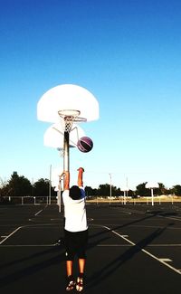 Man playing with ball against clear sky