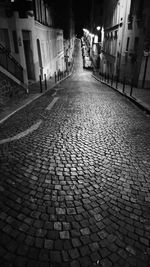 Cobblestone street in city at night