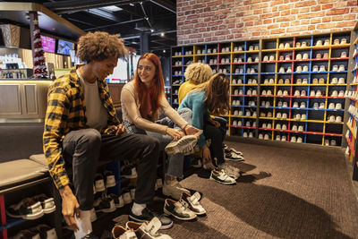 Portrait of smiling friends sitting in store