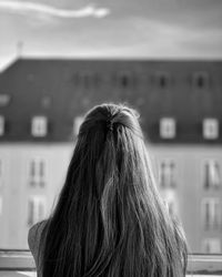 Rear view of woman against building and sky