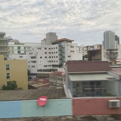 Buildings in city against cloudy sky