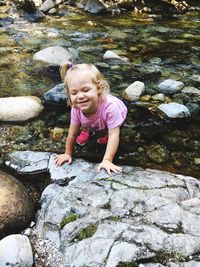 High angle view of girl by rock in river