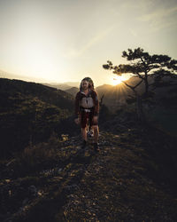 Hiker standing on mountain against sky