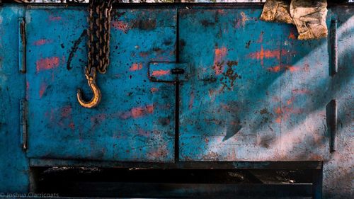 Close-up of rusty metal door with chain