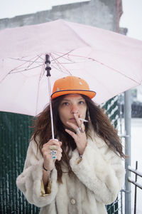 Portrait of young woman holding ice cream standing outdoors