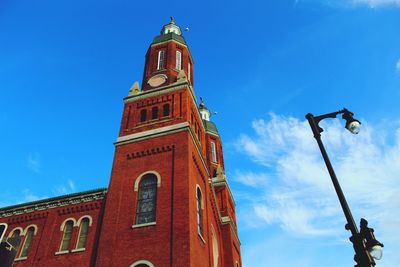 Low angle view of clock tower and building against blue sky