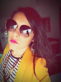 Portrait of woman wearing sunglasses at home