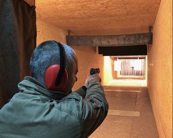 Rear view of military man practicing target shooting