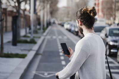 Man using mobile phone while standing on street