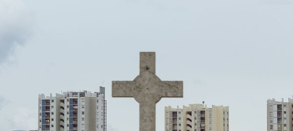 Low angle view of cross amidst apartment buildings, marseille, france