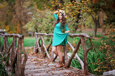 Portrait of young woman standing by plants