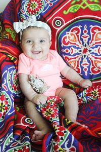 Portrait of cute baby girl on bed