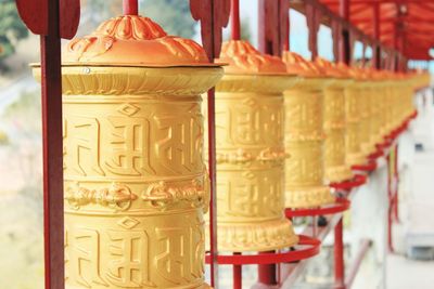 Close-up of prayer wheels in row at temple