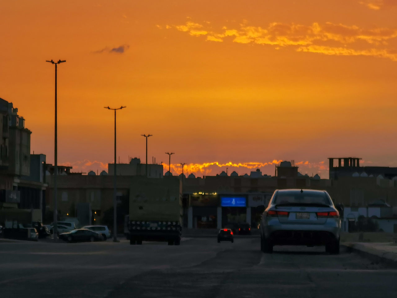 CARS ON ROAD AGAINST ORANGE SKY