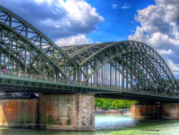 Bridge over river against cloudy sky