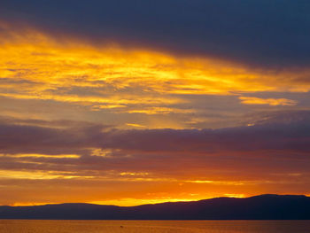 Scenic view of dramatic sky over sea during sunset