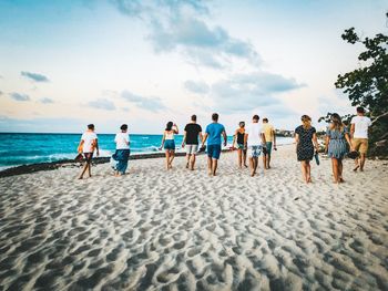 People at beach against sky