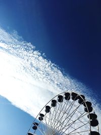 Low angle view of ferris wheel against blue sky