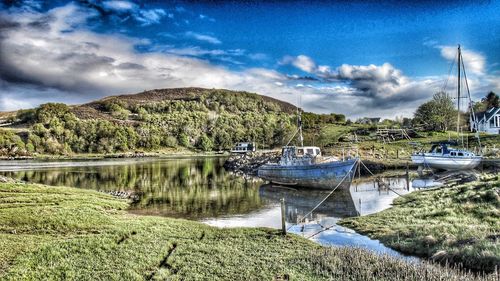 Boats moored in lake against sky