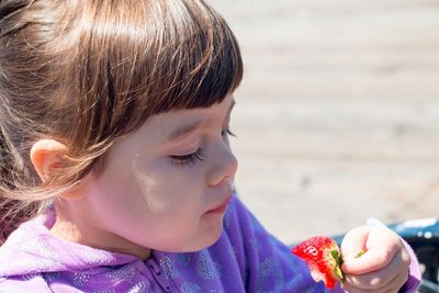 Close-up of girl having strawberry