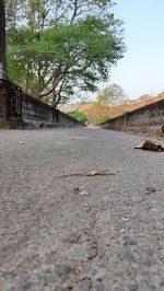 Surface level of footpath by road against sky