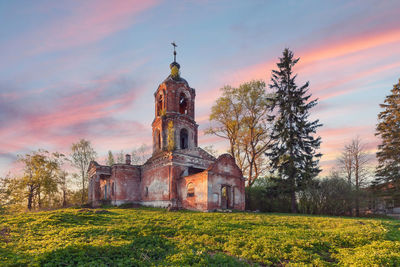 Abandoned brick orthodox church with a portico and columns at sunset