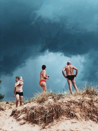 Young couple standing on land against sky