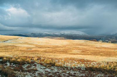 Scenic view of mountains against cloudy sky