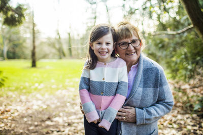 Grandma holds granddaughter in outdoor setting.