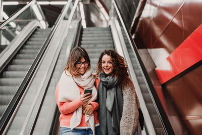 Woman standing on escalator