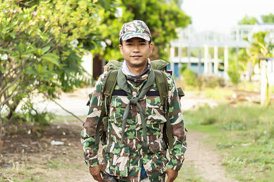 Portrait of young man standing against plants