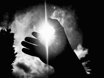 Low angle view of silhouette hand against sky