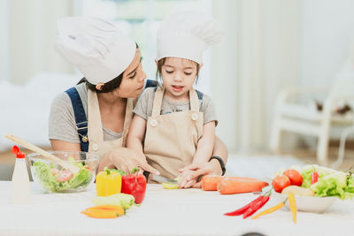 Midsection of woman having food in kitchen