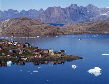 Scenic view of lake by mountains against sky