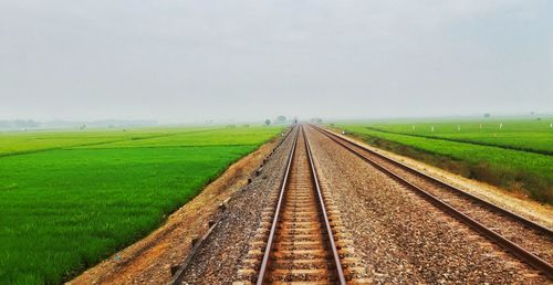 View of railroad tracks on field against sky