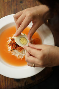 Cropped image of person having kimchi at restaurant