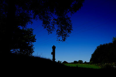 Silhouette trees against clear blue sky