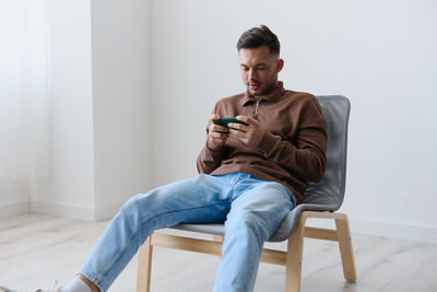 Young man sitting on sofa at home