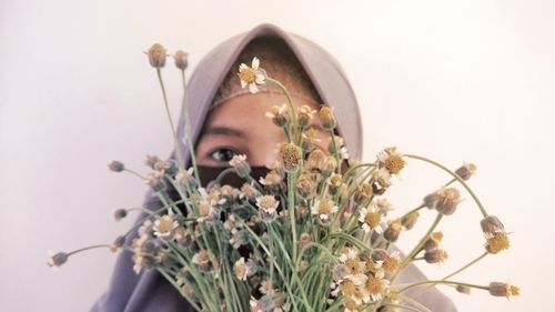 Portrait of woman against white flowering plants