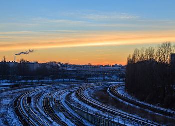 High angle view of snow covered field at sunset