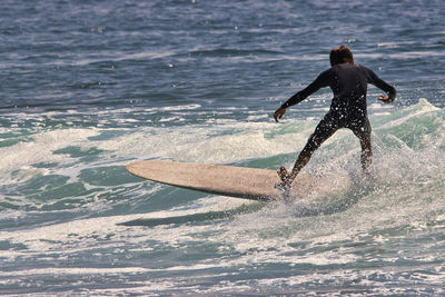 Full length of man splashing water in sea