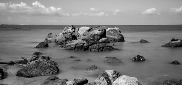 Scenic view of rocks in sea against sky