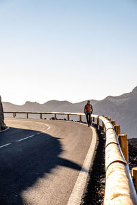 Sporty girl with backpack walking on a lonely road