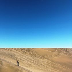 Scenic view of desert against clear blue sky