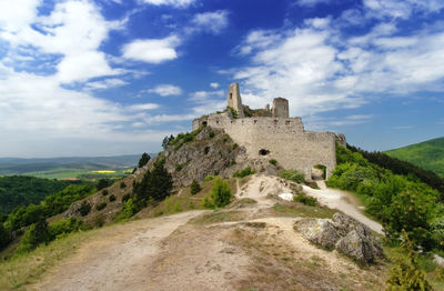 View of building on mountain against cloudy sky