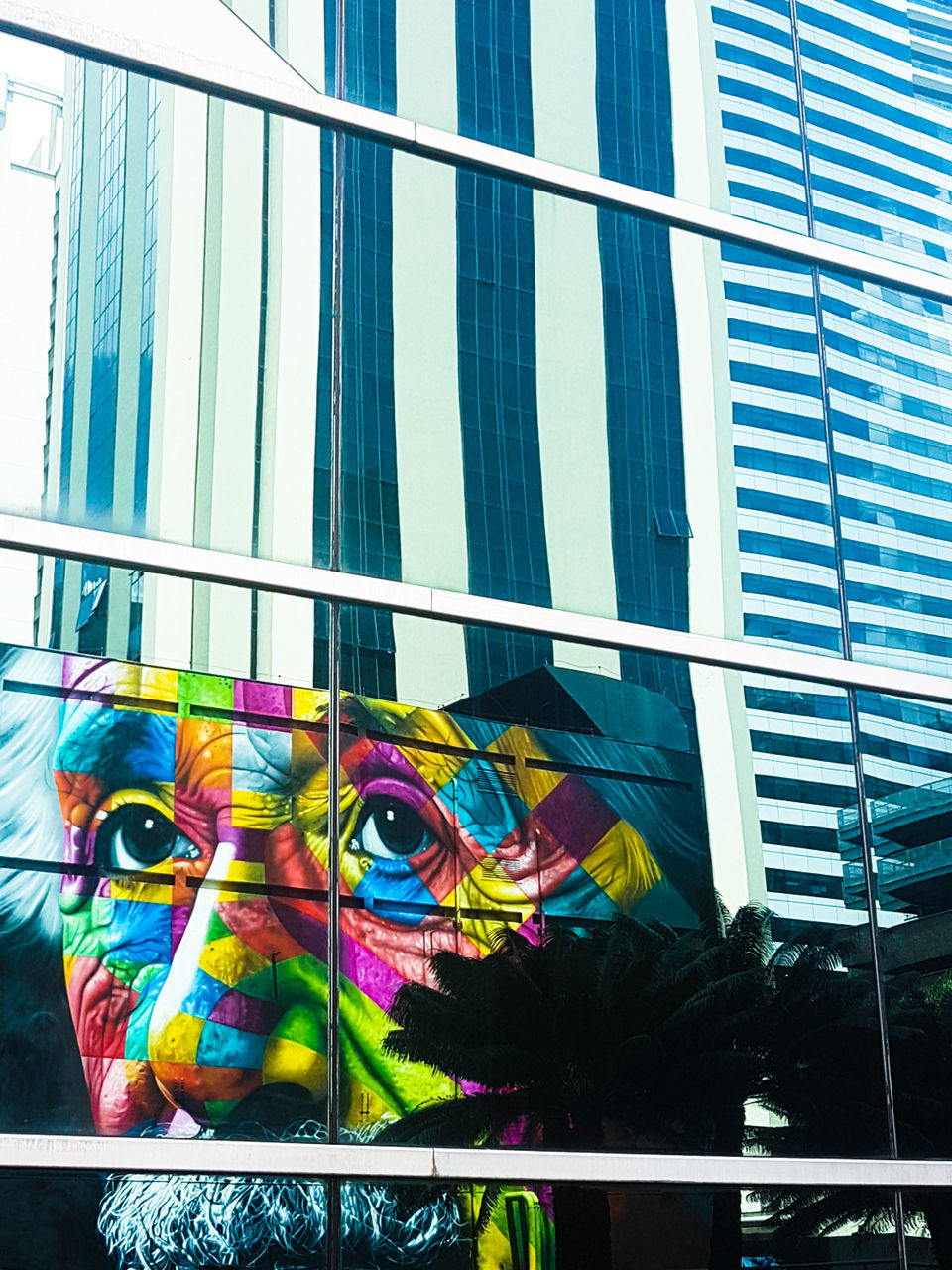 multi colored, architecture, built structure, building exterior, window, glass - material, building, art and craft, day, low angle view, no people, flag, outdoors, city, creativity, reflection, modern, celebration, glass