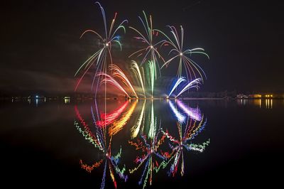 Reflection of firework display in river at night