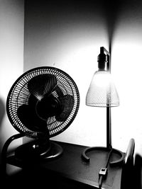 Close-up of electric lamp on table against wall