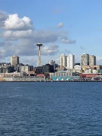 Sea by buildings against sky in city