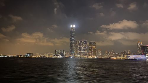 Illuminated buildings in city against sky at night